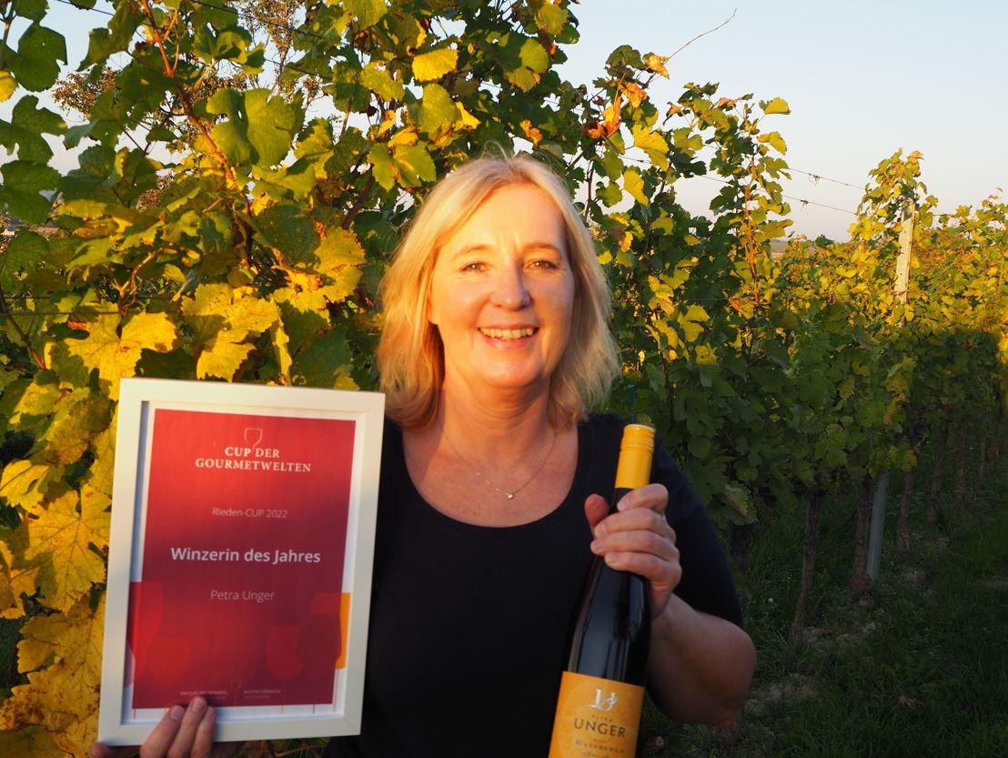 Winzerin Petra Unger mit Wein und Siegerurkunde