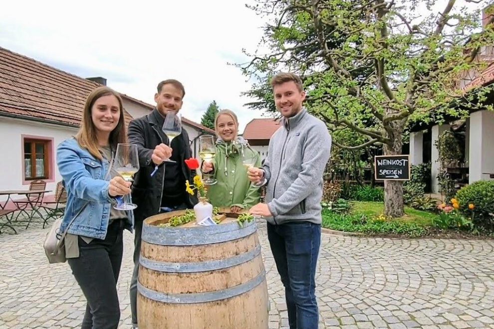 Zwei junge Paare im Hof eines Weinguts